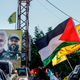 A supporter of the Lebanese Shiite movement Hezbollah waves Palestinian and Hezbollah flags.